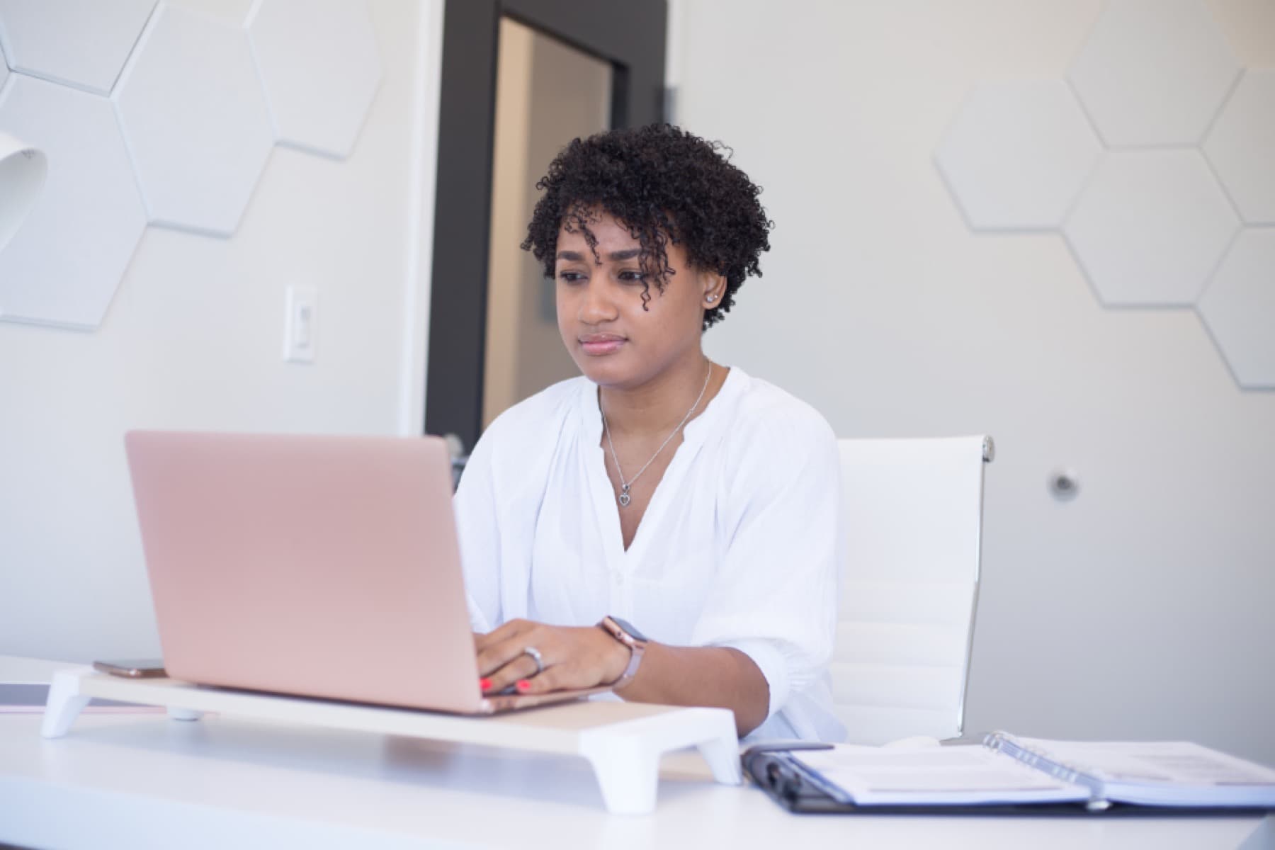 A designer working at a laptop in a bright studio