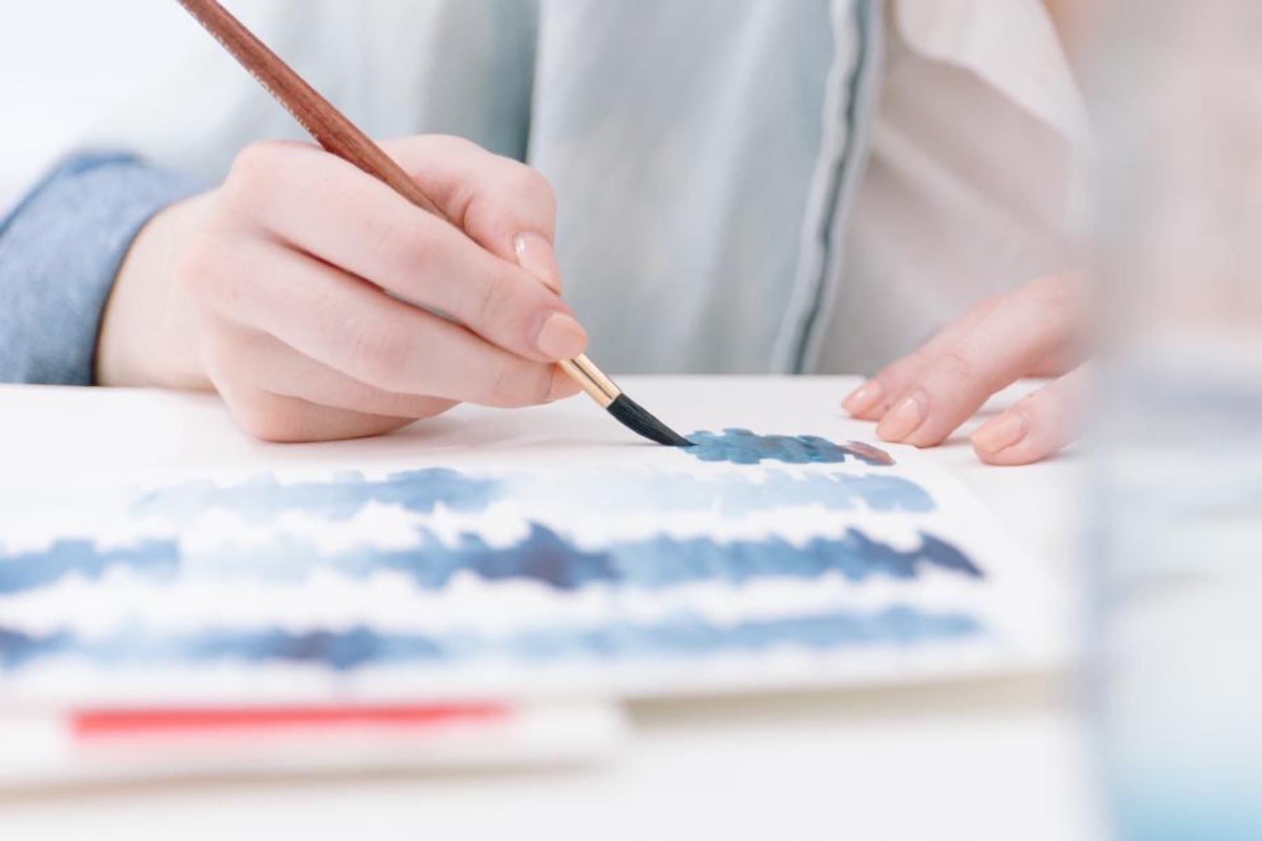 A hand painting colour swatches onto paper