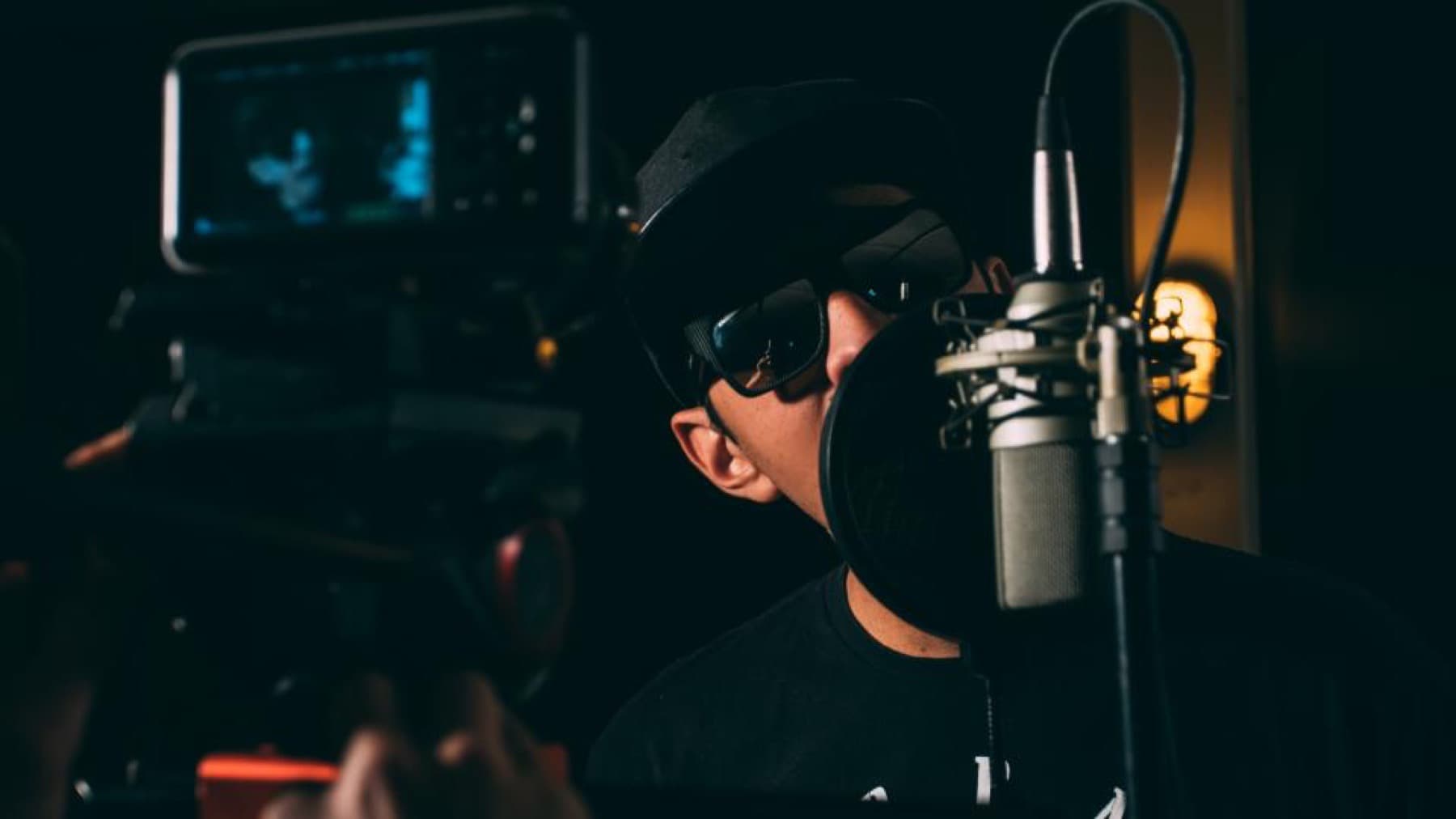 A broadcast microphone in a darkened studio